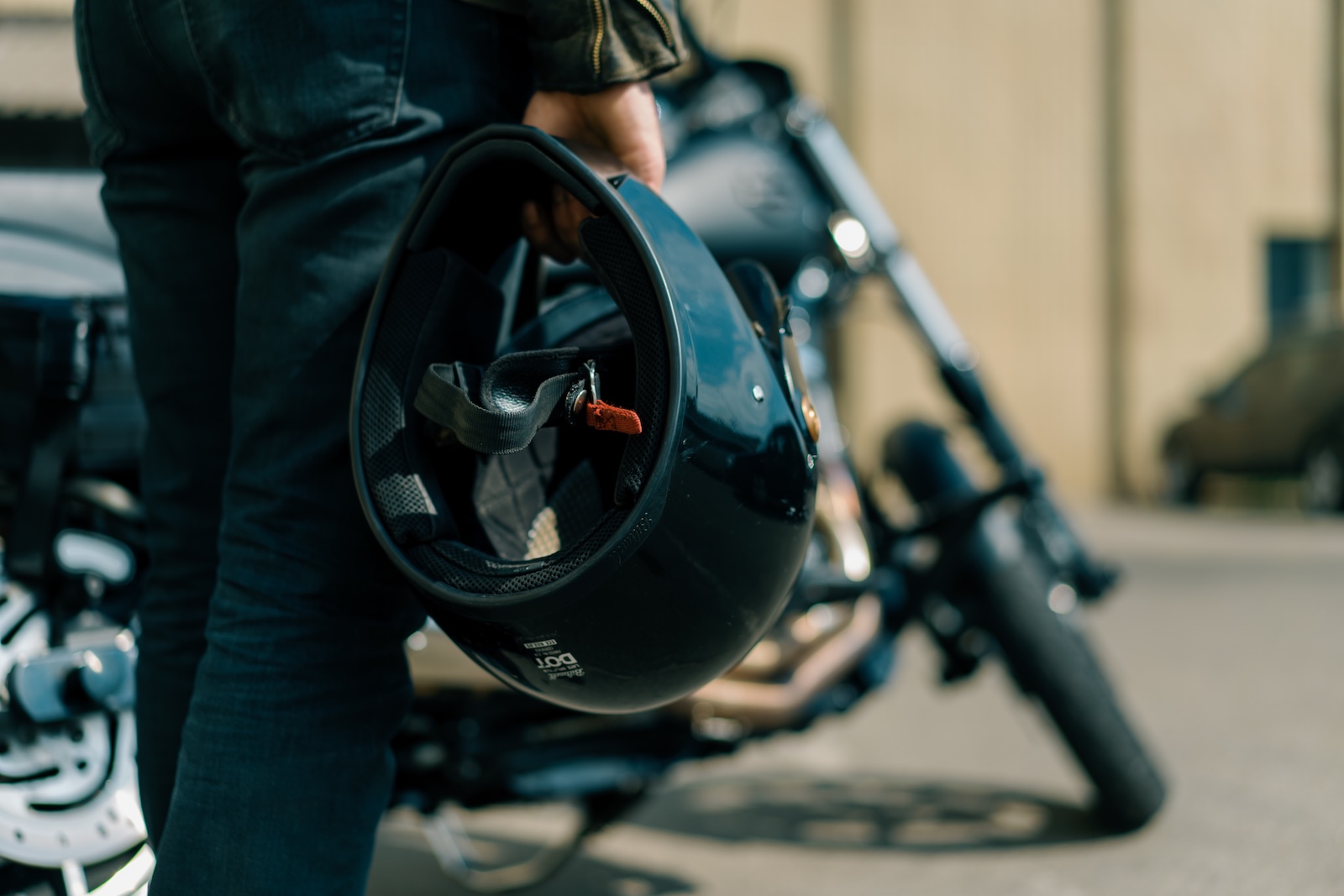 Blog - Franklin Law, LLC. biker standing near a black motorcycle holding a helmet in his hands